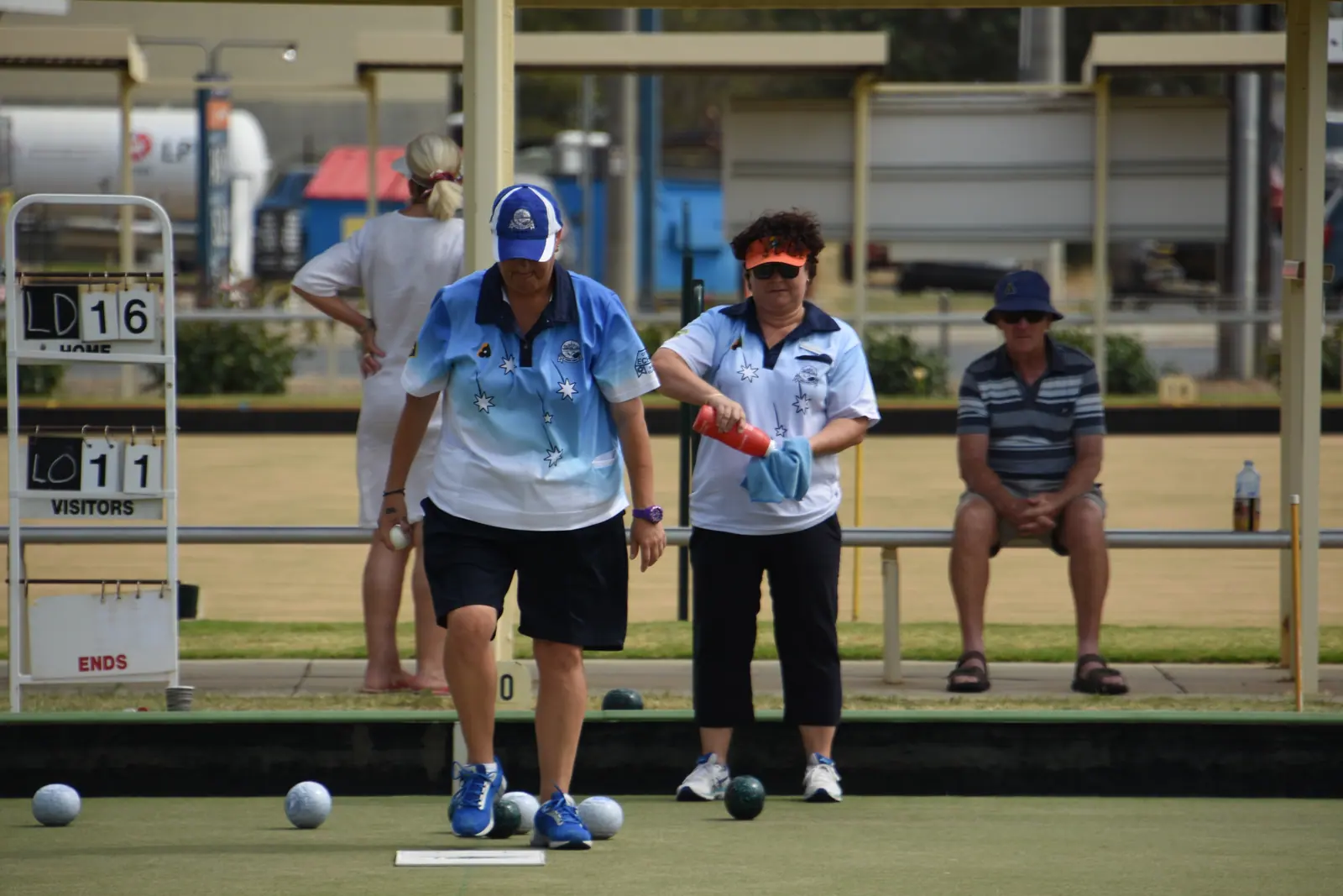 Two Echuca Bowls Club players beside the scoreboard