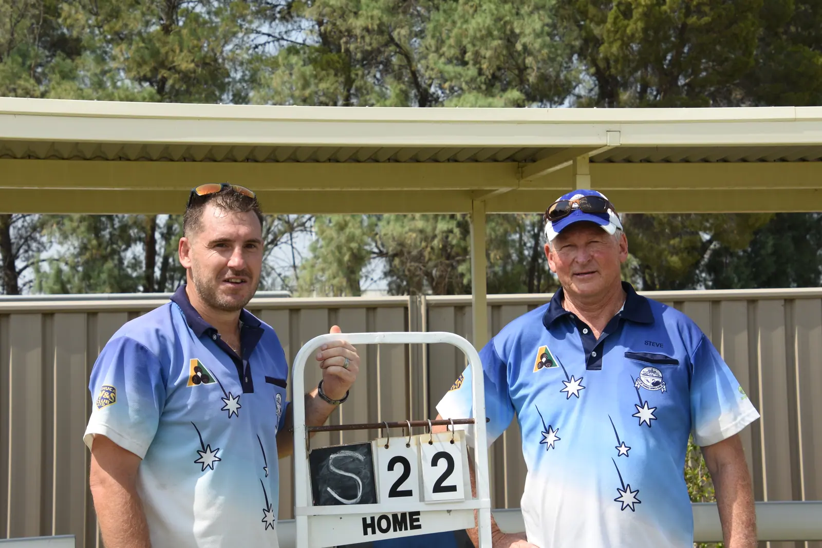 Two championship finalists standing beside the scoreboard reading 22