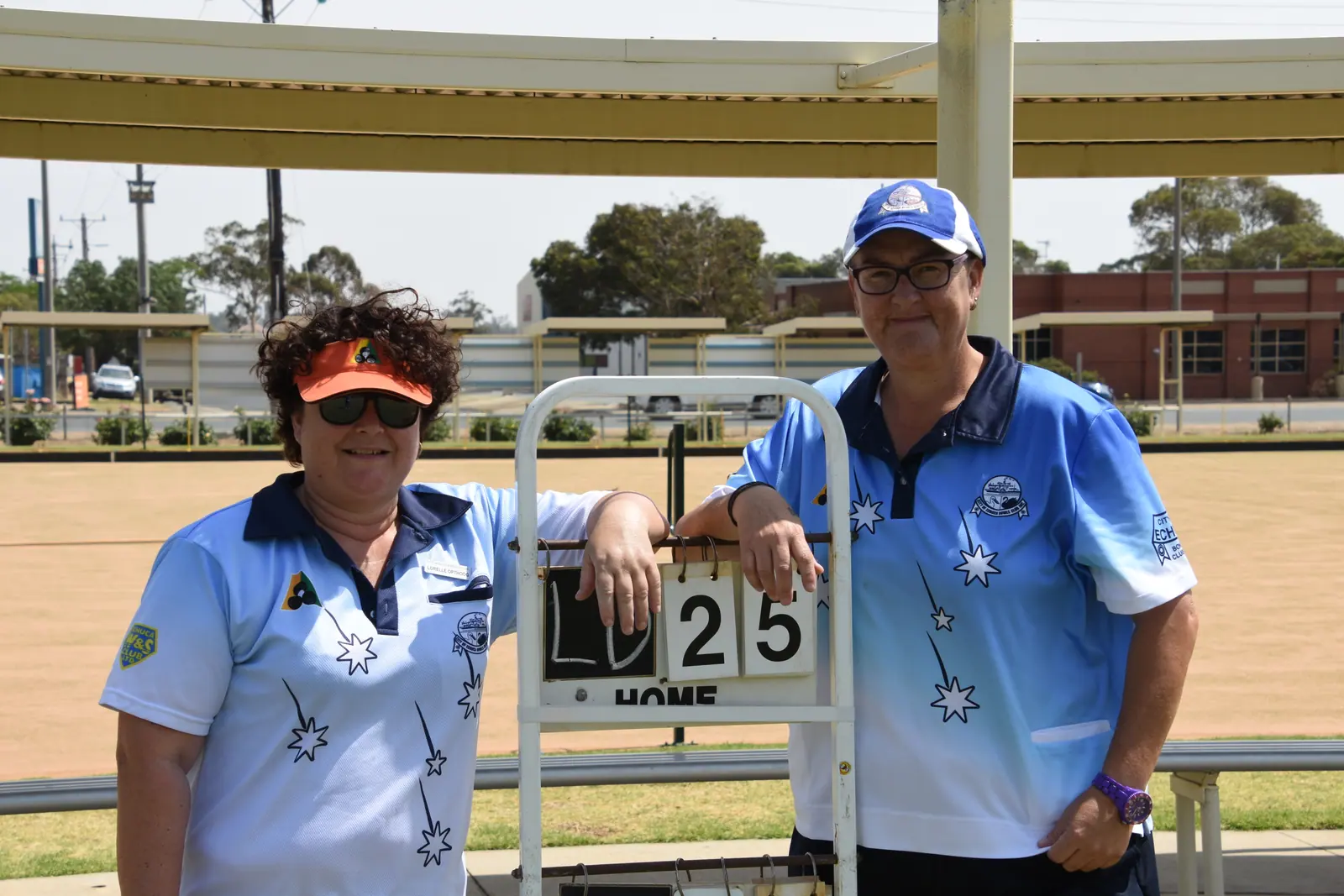 Mixed championship pair beside the scoreboard after their final