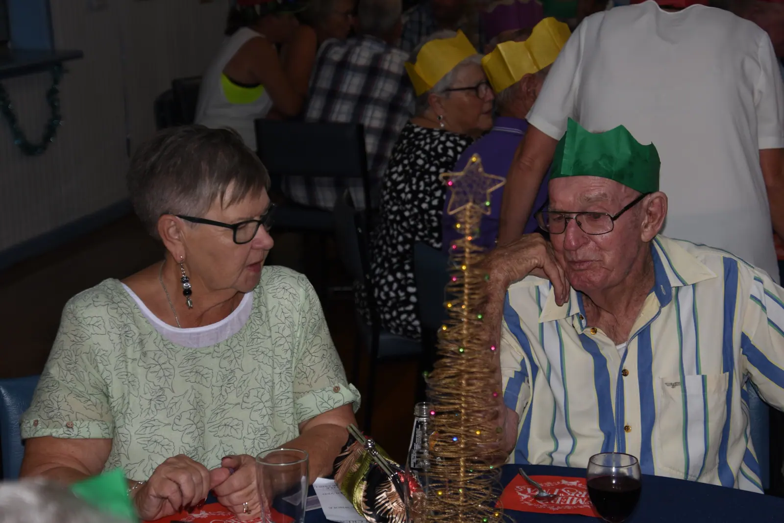 Members seated at a decorated table during the Christmas function