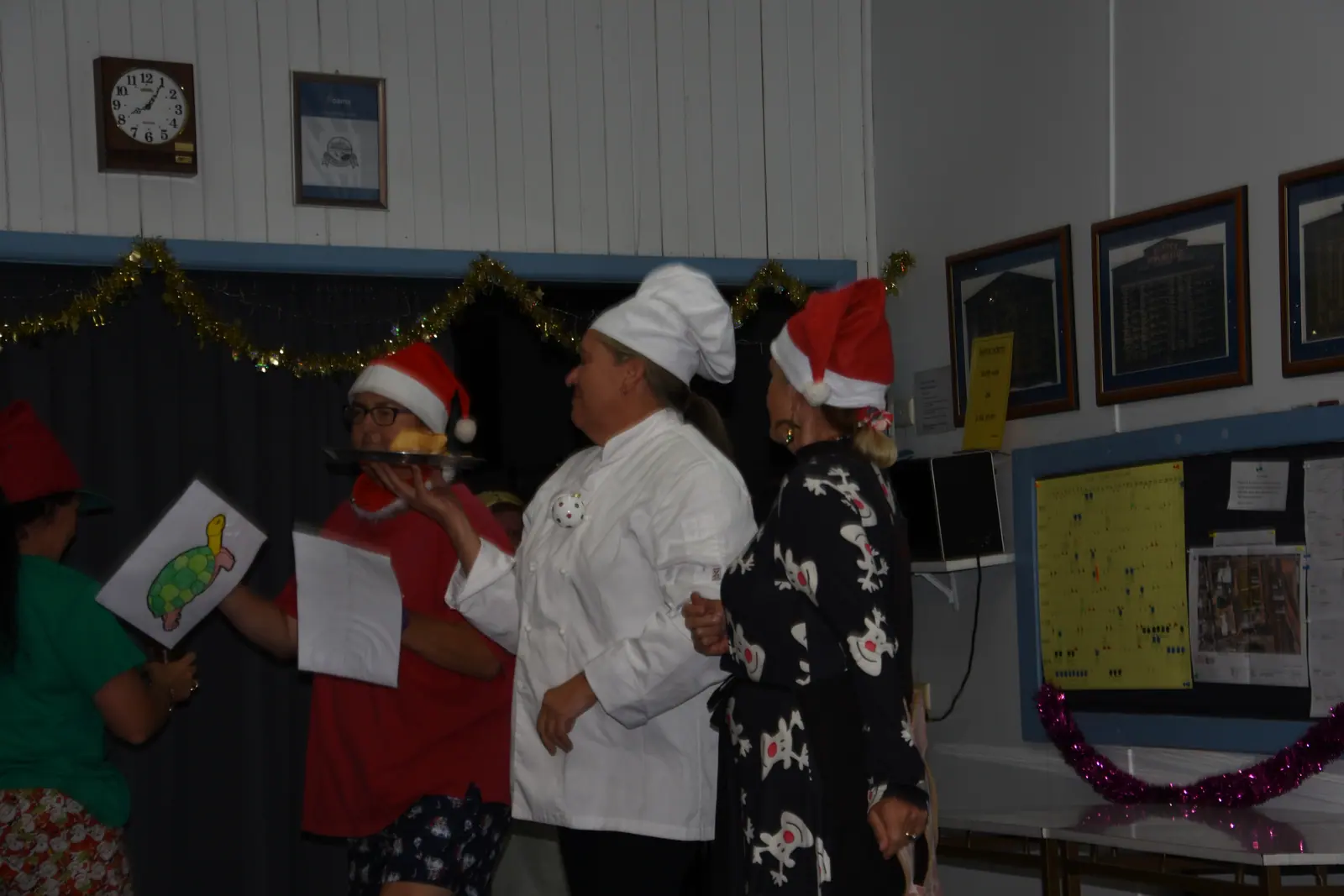 Members handing out gifts beneath the clubroom honour boards