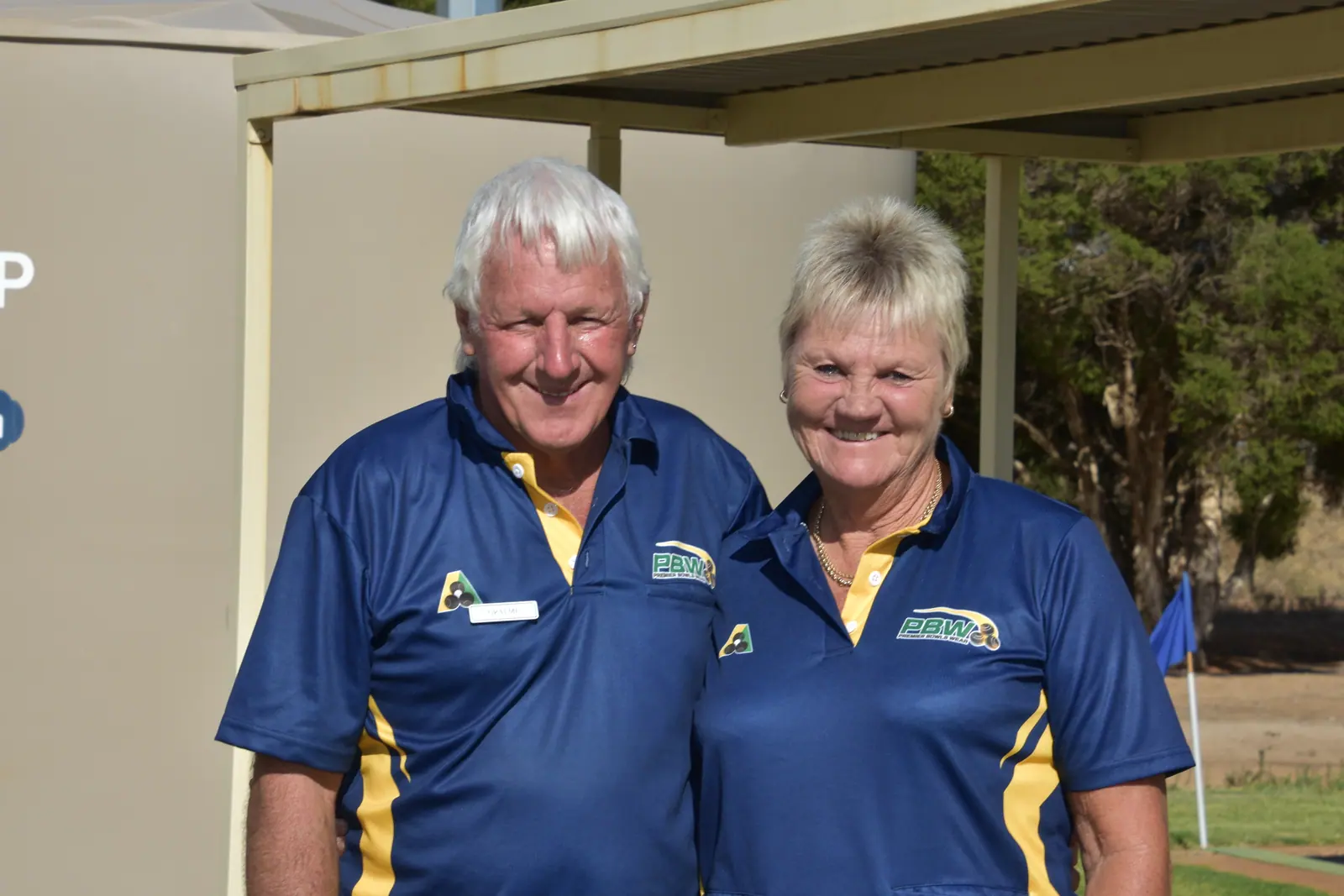 Two long-standing members in club colours outside the clubroom